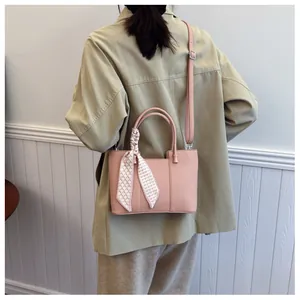Sac seau en cuir litchi rose avec foulard en soie décoratif sur la poignée et bandoulière