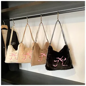 Selezione di borse in peluche beige e nere con ricami di fiocchi rosa e catena