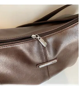 Détail de la fermeture éclair en métal argenté sur le sac cabas en cuir marron grainé