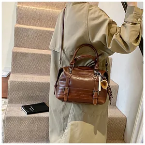 Detail van vintage oliewas lederen Boston tas met geweven bedel en verstelbare riem