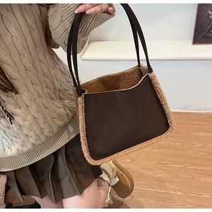 Detail of suede shoulder bag with faux shearling trim worn by model in casual outfit