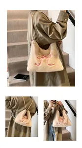 Dettaglio borsa tote in ecopelliccia beige con ricamo a fiocco rosa e tracolla a catena