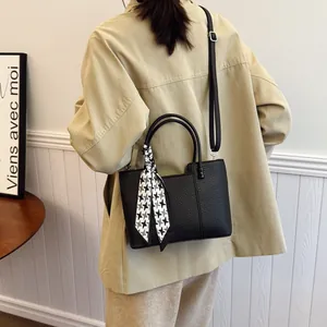 Sac à main noir en cuir grainé avec poignées doubles et un élégant foulard pied-de-poule