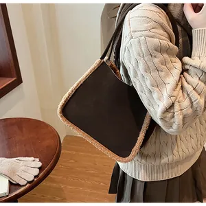 Detail of dark brown suede shoulder bag with plush fleece trim on female model