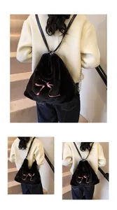 Dettaglio della borsa in ecopelliccia nera con fiocco rosa e catena metallica sottile