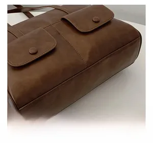 Close-up of vintage brown shoulder bag showing precision stitching and pocket details