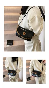 Detail of a black leather crossbody bag with decorative gold chain and metal buckle