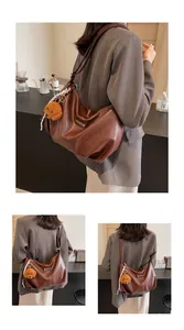 Vue détaillée du sac cabas marron avec breloque ours et foulard en soie décoratif