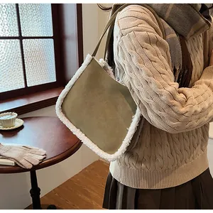 Close-up of olive suede tote bag with white faux shearling trim and slim shoulder strap