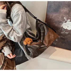 Vue détaillée du grand sac cabas bicolore marron avec boucle et breloque ours en peluche