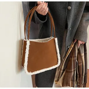 Detail of suede shoulder bag with faux shearling trim and slim leather handles
