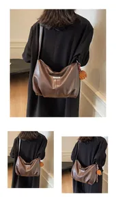 Détail du sac cabas marron en similicuir avec charm ours en peluche et texture plissée