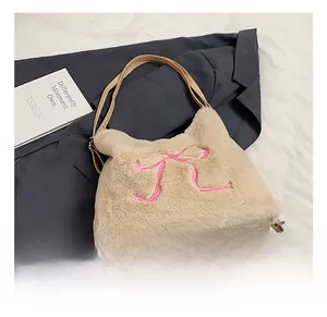 Vista dettagliata della borsa tote in peluche crema con ricamo a fiocco rosa e finta pelliccia