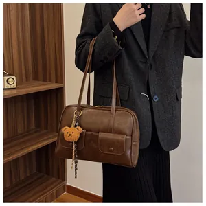 Brown vintage faux leather shoulder bag with two front pockets and plush bear charm