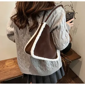 Detail of vintage brown suede bucket bag with white faux shearling trim and slim strap