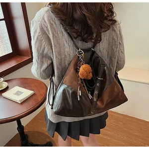 Détail d'un grand sac cabas vintage bicolore avec pendentif ours en peluche mignon