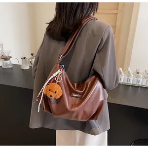 Sac cabas en cuir marron avec breloque chien en peluche et ruban sur bandoulière