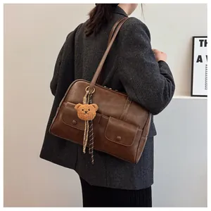 Retro brown leather underarm bag with front pockets and cute bear charm detail