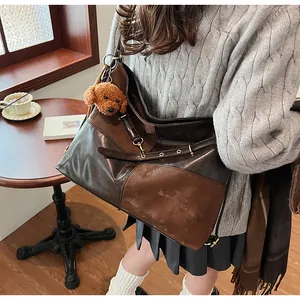 Détail d'un grand sac cabas vintage avec patchwork en cuir marron et pendentif chien peluche