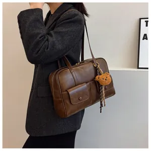 Detail view of a vintage dark brown shoulder bag featuring multiple front flap pockets