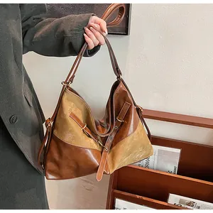 Gros plan sur les coutures contrastées et la texture cuir vintage du grand sac cabas