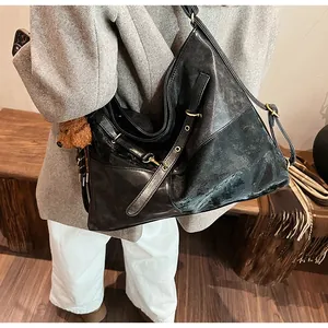 Vue détaillée du grand sac cabas noir vintage avec bandoulière réglable et breloque ours