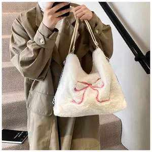 Dettaglio borsa tote bianca in peluche con fiocco rosa e tracolla in catena e pelle