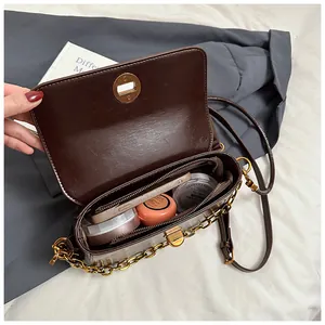Top view of brown crossbody bag showing spacious interior with phone and cosmetics