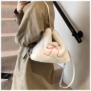 Dettaglio borsa shopper in finta pelliccia con fiocco rosa e tracolla a catena