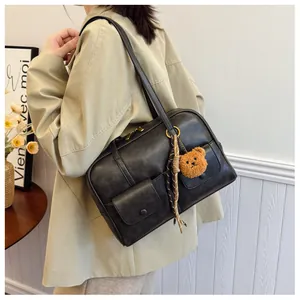 Retro black shoulder bag with dual front flap pockets and plush bear charm detail