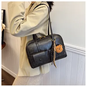 Macro shot of textured PU leather on a black shoulder bag with flap pocket detail