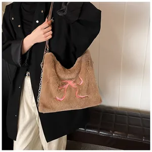 Dettaglio della borsa shopper in peluche marrone con fiocco rosa e tracolla a catena