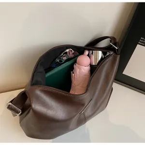 Grand sac fourre-tout en cuir marron foncé montrant le rangement d'articles divers
