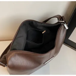 Détail de l'intérieur d'un sac cabas en cuir PU marron foncé avec fermeture éclair argentée
