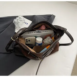 Vue macro de l'intérieur du grand sac fourre-tout bicolore avec livres et accessoires