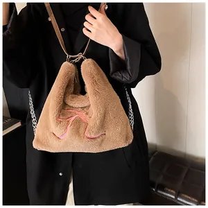 Dettaglio borsa tote in pelliccia sintetica con ricamo fiocco rosa e tracolla marrone