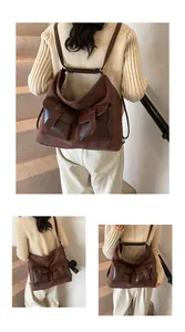 Detail of dark brown suede hobo bag with multi-pocket design and flap buckle straps