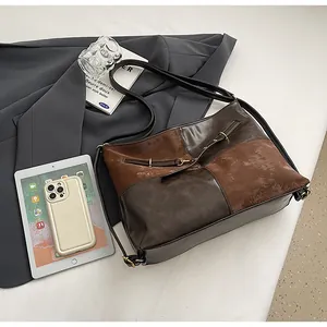 Détail du grand sac cabas avec design en patchwork marron sur tenue de bureau