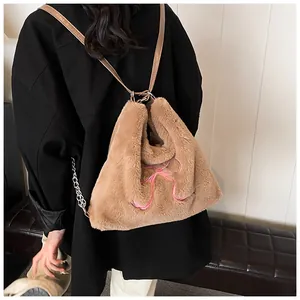 Dettaglio della borsa tote in peluche marrone con fiocco rosa e catena in metallo