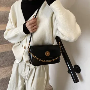 Elegant black leather square shoulder bag with gold chain and circular metal clasp detail