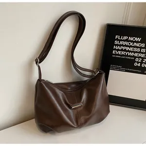 Détail du sac hobo en cuir marron foncé souple avec ferrures argentées et bandoulière