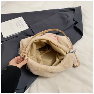 Dettaglio dell'interno spazioso della borsa tote in peluche crema con ricamo rosa