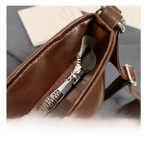 Detail of silver metal zipper on dark brown leather bag with high-quality stitching