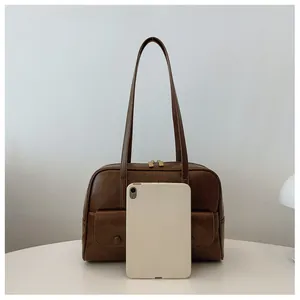 Brown retro underarm bag showing large capacity with a white tablet reference