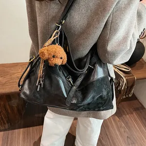 Grand sac hobo noir en cuir brillant avec un charme de chien mignon et détails à rivets