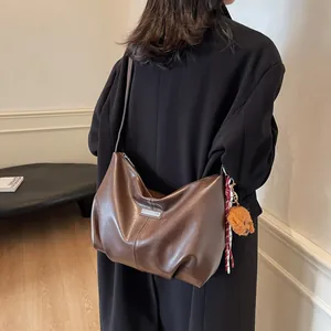 Sac fourre-tout tendance en simili cuir marron foncé avec breloque ours porté par mannequin