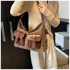 Brown tweed shoulder bag with dual leather flap pockets shown on model in studio