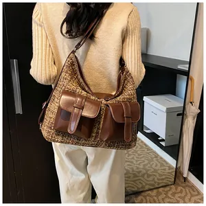 Detail of vintage brown tweed hobo bag with dual pockets shown on model's shoulder