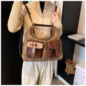 Detailed view of brown tweed shoulder bag with leather pockets and textured fabric