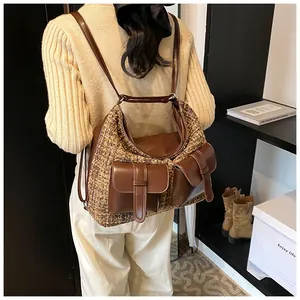 Detail of a large brown tweed and PU leather multi-pocket backpack on a female model